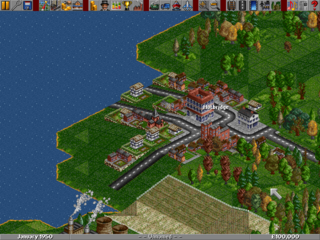 An isometric city-building view displays a developed railway and road network with multiple colored trains, stations, and vehicles positioned across a terrain of grass, forests, and water. The landscape features industrial buildings, residential structures, and farmland arranged in a grid-like transportation infrastructure. A blue water body occupies the left side of the screen, while a toolbar with game icons appears at the top of the interface. The art style uses low-resolution pixel graphics with a characteristic 1990s isometric perspective and limited color palette of greens, blues, browns, and reds.