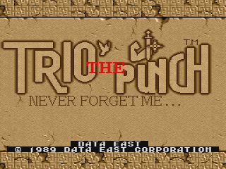 The title screen displays 'TRIO THE PUNCH' in large tan outlined letters against a textured beige background resembling cracked stone or aged plaster. Red text reading 'NEVER FORGET ME...' appears beneath the main title. At the bottom of the screen, white text states '©1989 DATA EAST CORPORATION'. The overall color palette consists of warm browns and tans with minimal contrast, typical of late-1980s arcade game aesthetics.