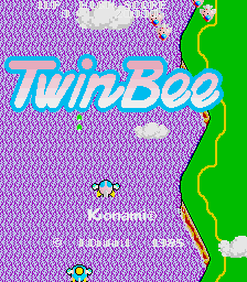 The TwinBee title screen displays the game's logo in large cyan letters across the center, set against a magenta checkerboard background with white noise texture. A bright green wavy border forms the right edge of the screen. Small white clouds and yellow bee sprites are scattered across the upper portion, with additional yellow and pink bee-like characters positioned in the lower-left area. The overall visual style uses vibrant neon colors typical of 1980s arcade graphics with low-resolution pixel art.