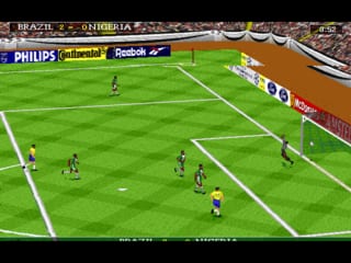 A top-down soccer pitch displays two teams in mid-match, with Brazil indicated at the top left scoreboard. The green field shows eleven players positioned across the pitch, with the ball visible in play. White boundary lines mark the field edges and center line. Sponsor logos including Philips, Reebok, and other brand names line the sidelines. The graphics use a low-resolution sprite-based style typical of DOS-era sports games, with simple polygonal player models and flat color palette rendering the players in contrasting team kits.