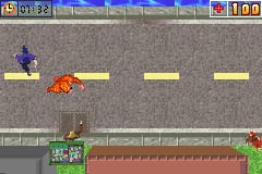 A side-scrolling level displays a red yeti character in mid-leap above a gray asphalt road with yellow dashed lane markings. Below the road, a green platform with red brick texture forms the ground level. A red enemy creature appears in the lower right. The top UI shows a score display with "100" visible and a health or status bar. The sprite-based graphics use a limited color palette typical of Game Boy Advance hardware, with distinct pixelated character and environmental designs.
