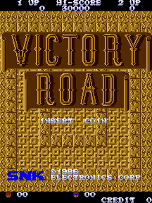 The title screen displays "VICTORY ROAD" in large golden outlined letters against a brown textured background with a geometric diamond pattern. Below the title, white text reads "INSERT COIN" in a classic arcade font. At the bottom of the screen, a blue horizontal bar contains "PRESS START BUTTON" in white text, with "CREDIT" visible in the lower right corner. The entire composition uses a limited color palette of brown, gold, white, and blue typical of mid-1980s arcade cabinets.