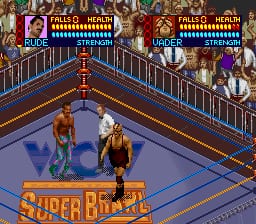 A wrestling match in progress inside a blue-roped ring, featuring two fighters—one in brown trunks and one in yellow—positioned in the center. The "SUPER BRAWL" logo is visible on the mat. Two health bars appear at the top left and right of the screen displaying fighter names and energy levels in blue. The background shows ornate red and gold patterned wallpaper with metal railings, indicating an indoor arena setting. The graphics use the low-resolution sprite style typical of early 1990s SNES wrestling games.