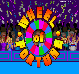 A colorful arcade title screen displays a large spinning wheel divided into segments in bright colors—magenta, cyan, yellow, orange, and green—with "01" at its center. The word "WHEEL" arcs above the wheel in yellow capital letters, while "OF FORTUNE" appears below in matching text. Stylized contestant figures in various colors stand on either side of the wheel against a purple background dotted with small white icons. A blue platform spans the bottom of the screen. "CREDITS 13" appears in white text at the top right corner.