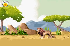A cartoon-style savanna scene features a brown lion standing in the center-right of the sandy terrain, facing left. Two tan-colored camels stand to the left, and green vegetation including acacia-like trees with broad crowns frames the upper portion of the scene. Mountains appear in the middle distance under a light green sky with white clouds. The sprite-based graphics use a warm color palette of browns, greens, and tans typical of Game Boy Advance resolution.