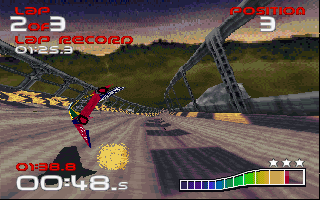 A futuristic racing craft flies left across a desert track with rocky terrain and a distant mesa horizon. Red and blue UI elements display lap time 00:48.5 in lower left, with a colorful health/shield bar at bottom right. Score counter showing 22 and 9 appears in top corners. The craft leaves a trail effect, and the scene uses 3D polygon graphics with a sandy, low-detail environment typical of mid-1990s PC gaming.