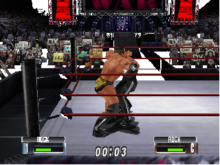 A wrestling match in progress shows two fighters in a ring with a crowded arena in the background. The shirtless wrestler on the left wears black pants and is in a grappling position against an opponent on the right. The UI displays health bars labeled "MIX" and "ROCK" at the bottom with a timer reading "00:03". Red pillars frame the arena structure, and spectators fill the seats behind the wrestling ring. The graphics use the low-polygon 3D style typical of N64 wrestling games with a detailed crowd and realistic arena lighting.