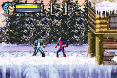 Two characters face off on an icy platform in a snowy environment. The character on the left wears blue, while the one on the right is dressed in magenta. A yellow health bar and blue energy meter sit at the top left of the screen. The background shows a dark forest of evergreen trees with snow, and wooden structures visible on the right side. The foreground features white ice formations at the bottom of the screen. Pixelated 16-bit sprite graphics throughout, typical of Game Boy Advance action games.