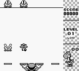 A Game Boy screenshot displays a simple puzzle game interface with Yoshi as the central character. The top-right corner shows score readout "00000" and text elements for "LEVEL" and "00". Two small enemies or objects appear in the upper-left area. The lower portion features a curved arc or bowl shape in black pixels, with symmetrical horizontal lines flanking it. The monochrome green display uses basic pixel sprites typical of Game Boy hardware.