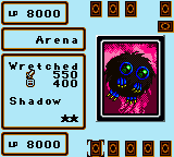 A Game Boy screen displays a Yu-Gi-Oh! Duel Monsters card battle interface. The left panel shows "Arena" with "Wretched" and "300 Shadow" text below, bracketed by 0000 score displays at top and bottom. The right side features a large circular card image with a pink and dark color palette showing what appears to be a monster design. Small card icons line the top and bottom edges of the screen. The overall layout uses the typical monochrome and limited-color palette characteristic of Game Boy graphics.