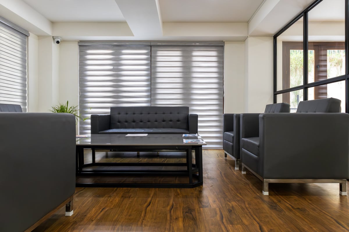 Meeting lounge with grey seating and a wooden floor