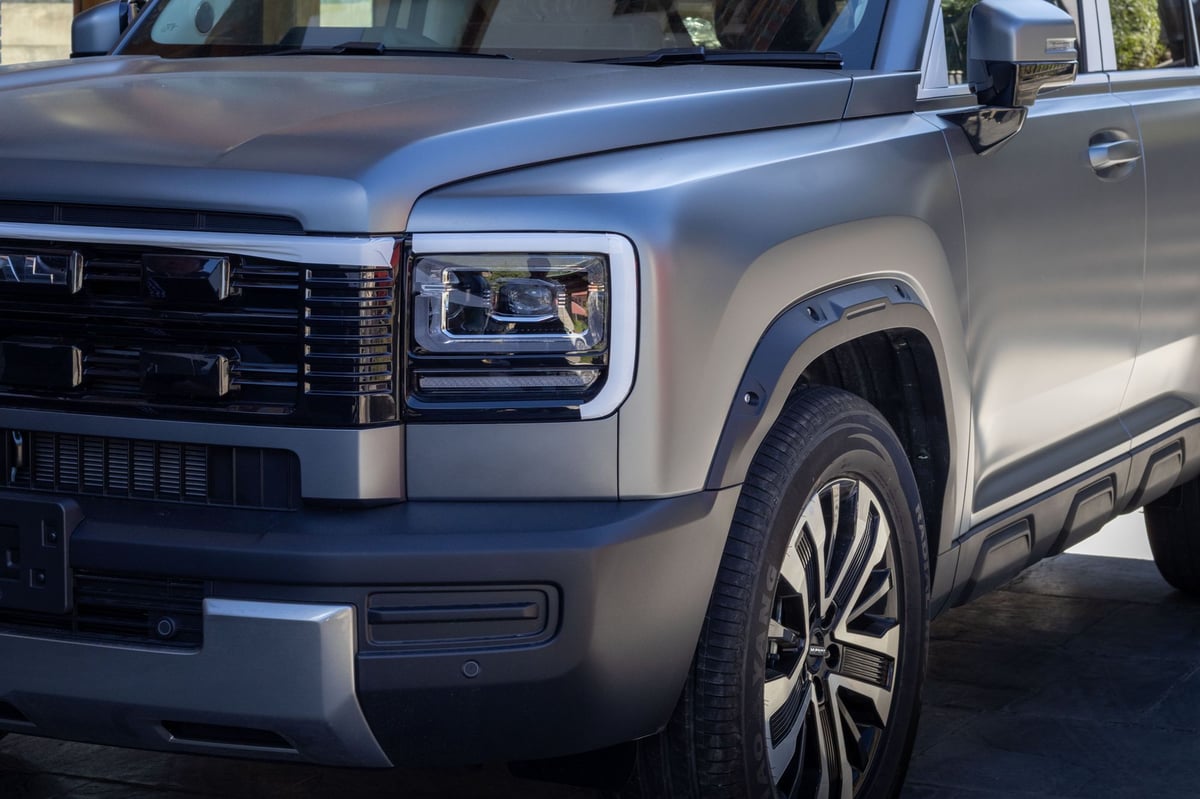 Close-up of the Haval H7 headlamp and flared front wheel arch in matte grey