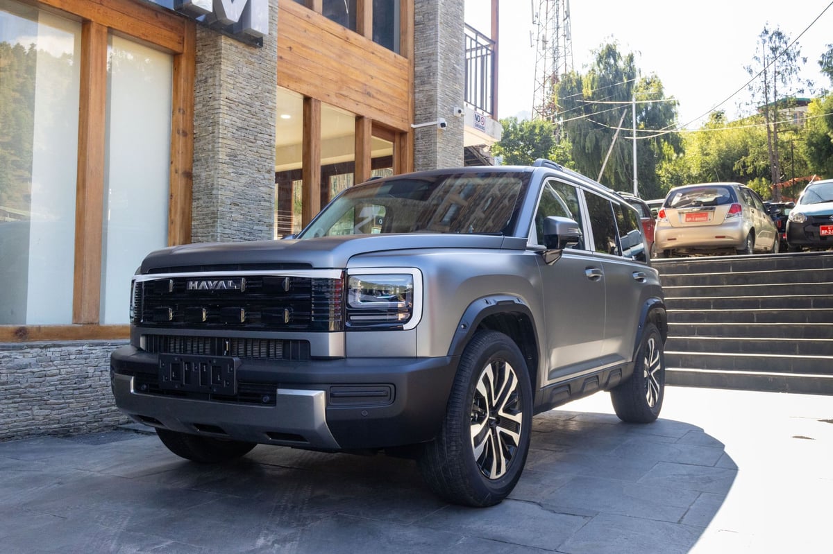 Matte-grey Haval H7 parked on the stone forecourt outside the showroom