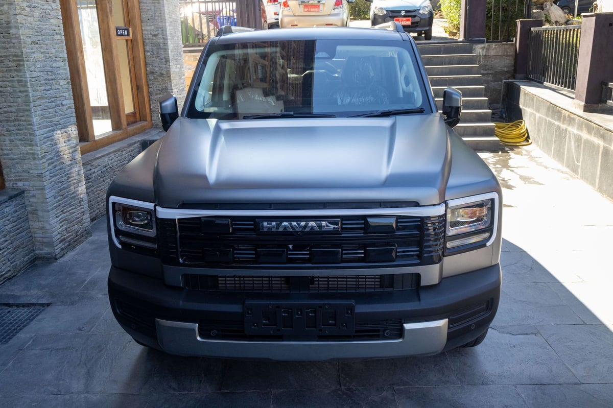 Haval H7 photographed head-on outside the showroom, full-width grille and HAVAL lettering