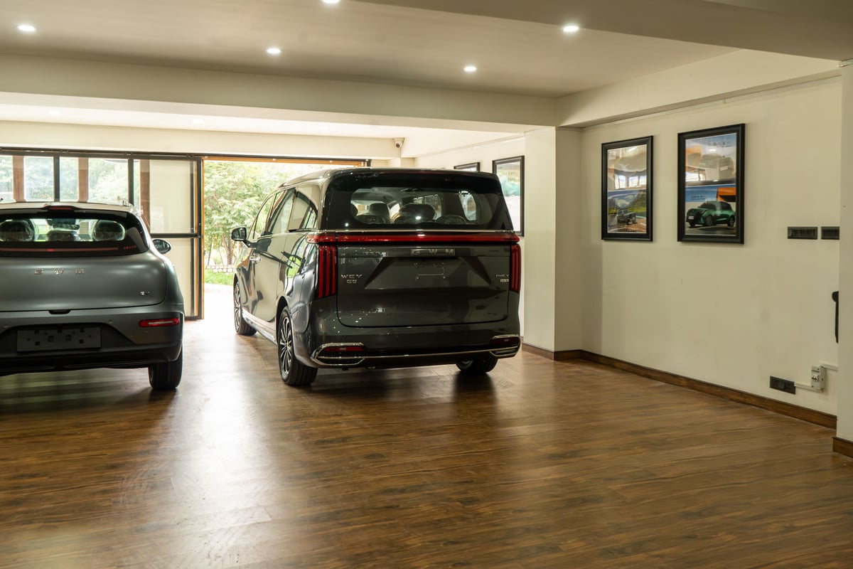ORA 5 and WEY G9 on the showroom floor with the valley visible through the glazing