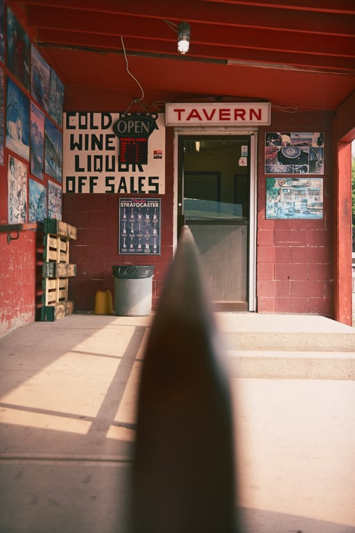 The red entrance of a Coleman tavern beneath signs for cold wine, liquor and off-sales.