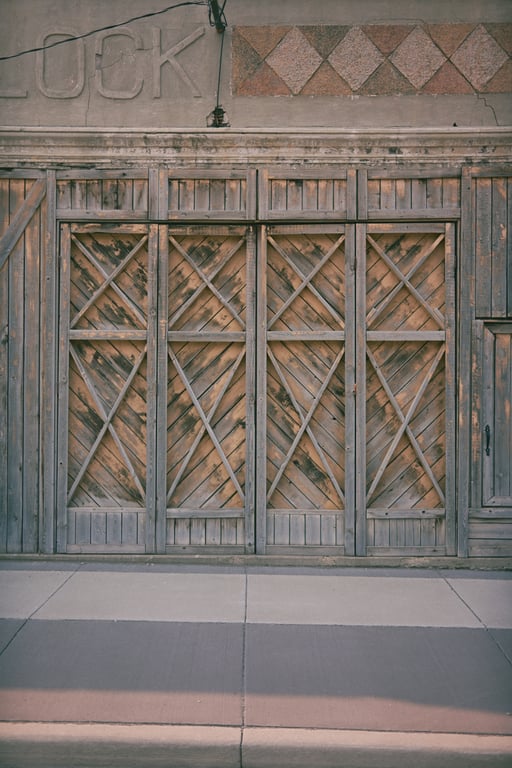 Close view of tall, weathered and cross-braced wooden doors on the Morrison Block.