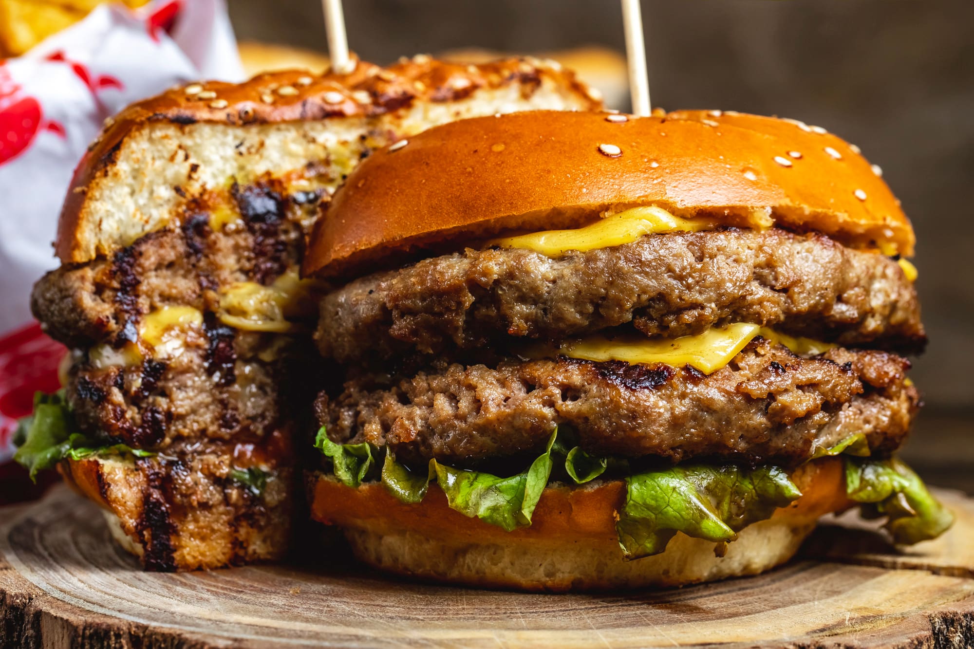 Side view of a double cheeseburger with beef patties, cheese, and lettuce