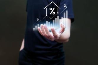 A man's hand interacting with a data analytics graph displayed on a virtual screen, symbolizing the concept of real estate investment