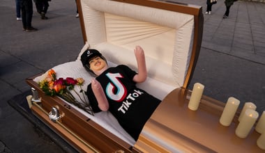 Coffin containing a blow up doll, dressed in TikTok merch is used by comic Zach Sage, who posts content on TikTok, as he films in Washington Square Park in New York City