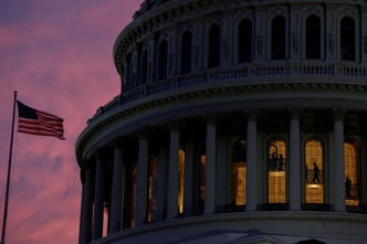 People walk inside the upper floors of the rotunda of the U.S. Capitol building at sunset in Washington