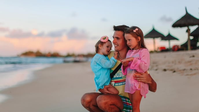 A young dad enjoying a vacation with his two young daughters