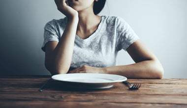 Woman with an Empty Plate Struggling with Eating Disorders