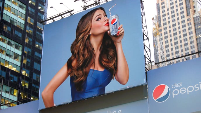 A billboard showing a young attractive woman on a Pepsi advertisement