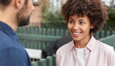 A cheerful young girl is gently listening to her friend as they talk