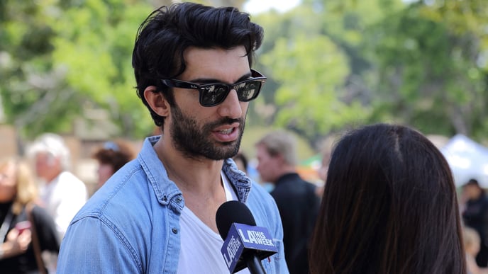 Actor Justin Baldoni talks to a reporter at the “Rocket’s Universe” grand opening, which is the 64th universally accessible playground built by Shane’s Inspiration