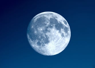 Full moon seen with an astronomical telescope over blue sky. Photo by Shutterstockcom - Claudio Divizia