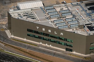 1 May 2024, Berlin, Germany. Aerial view of Tesla Gigafactory in German Grünheide. Huge text logo at entrance of office. The car factory manufactures electric cars.