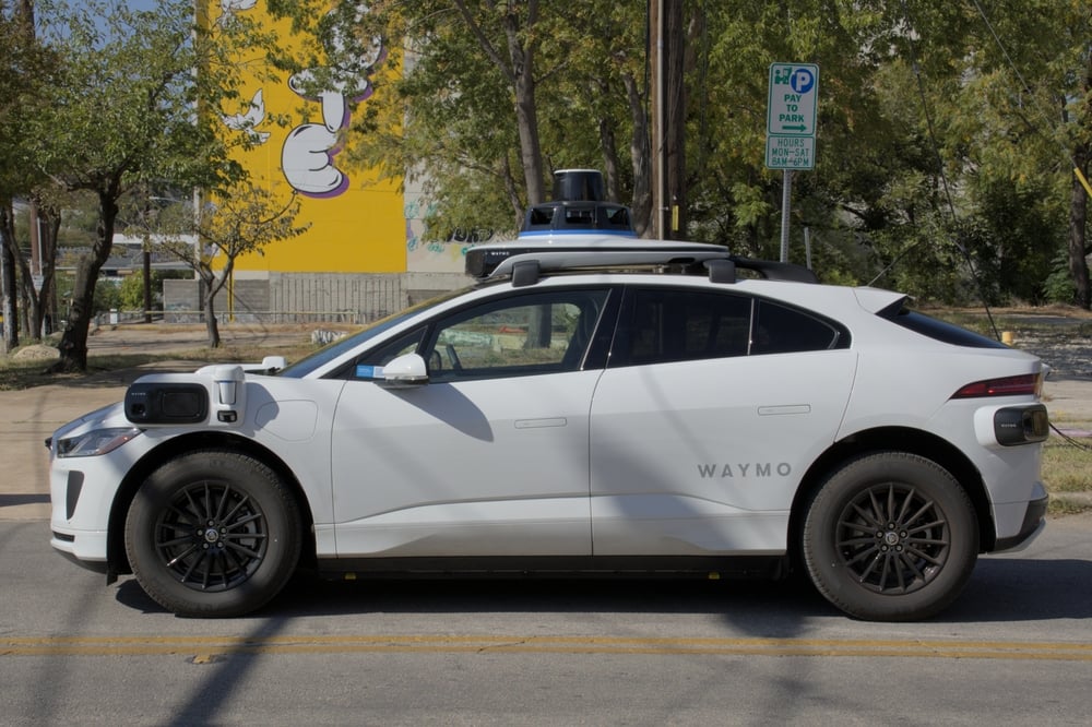 Profile image of a white Waymo autonomous vehicle clearing showing the lack of a driver