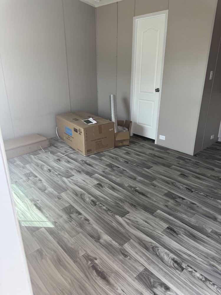 Bedroom with wood-look flooring in Legacy oilfield crew housing for Midland Odessa