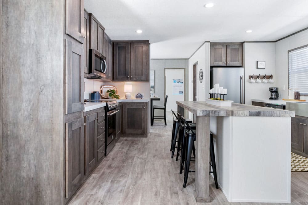 Kitchen island and dark wood cabinets in The Wilson single-wide manufactured home