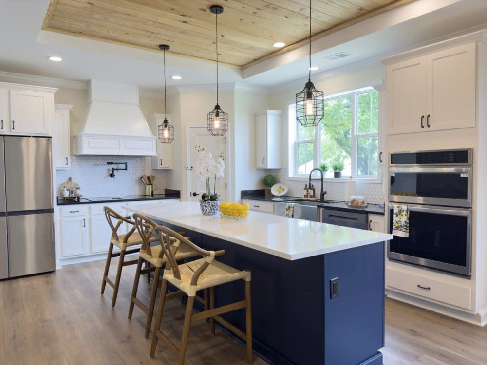 White kitchen with navy island and pendant lights in The Riverwalk