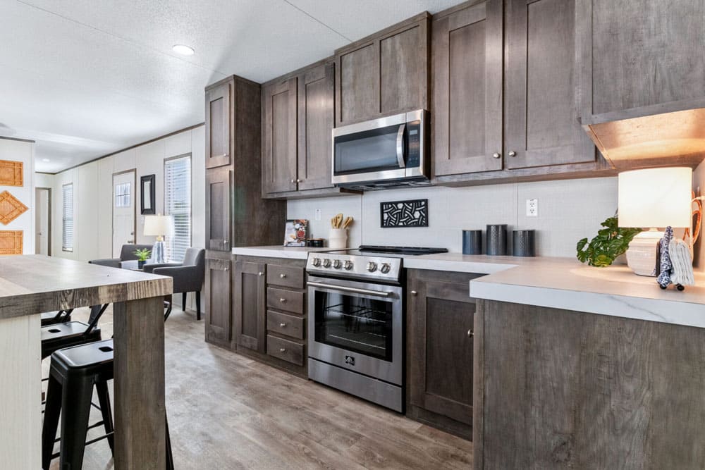 Stainless range, microwave and hardwood cabinets in The Wilson by Jessup Housing