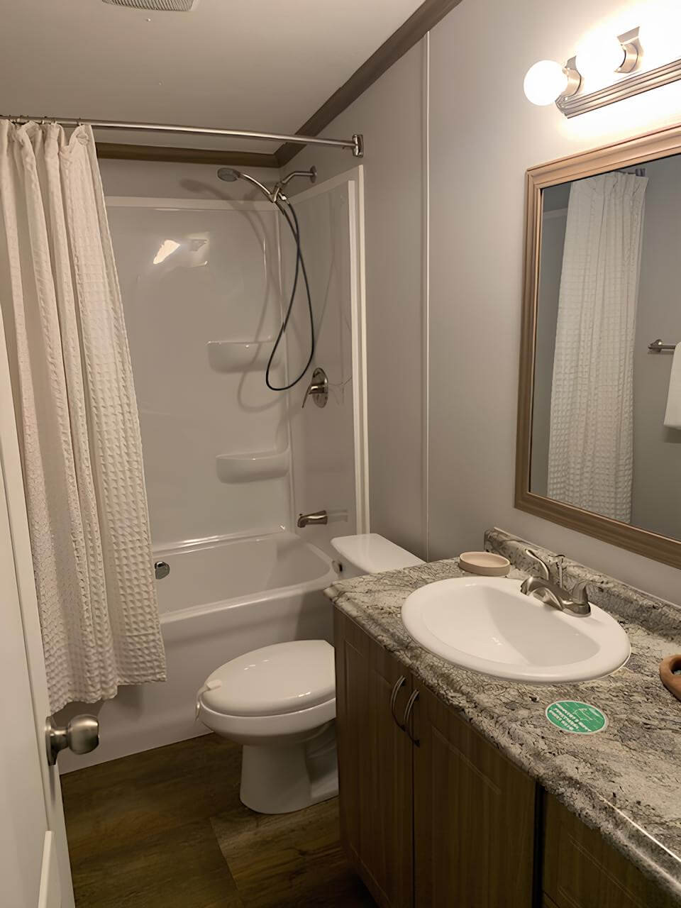 Guest bathroom with tub and shower in The Lakehouse manufactured home