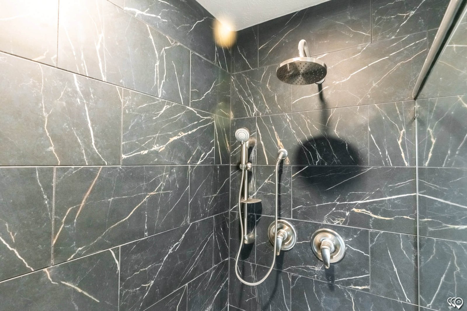 Rainfall and handheld shower fixtures in The Trinity CS-3242 primary bathroom