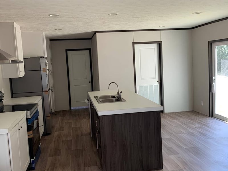 Open kitchen and dining area in The Colossal Ultrawide 18x80 in Bonham, TX