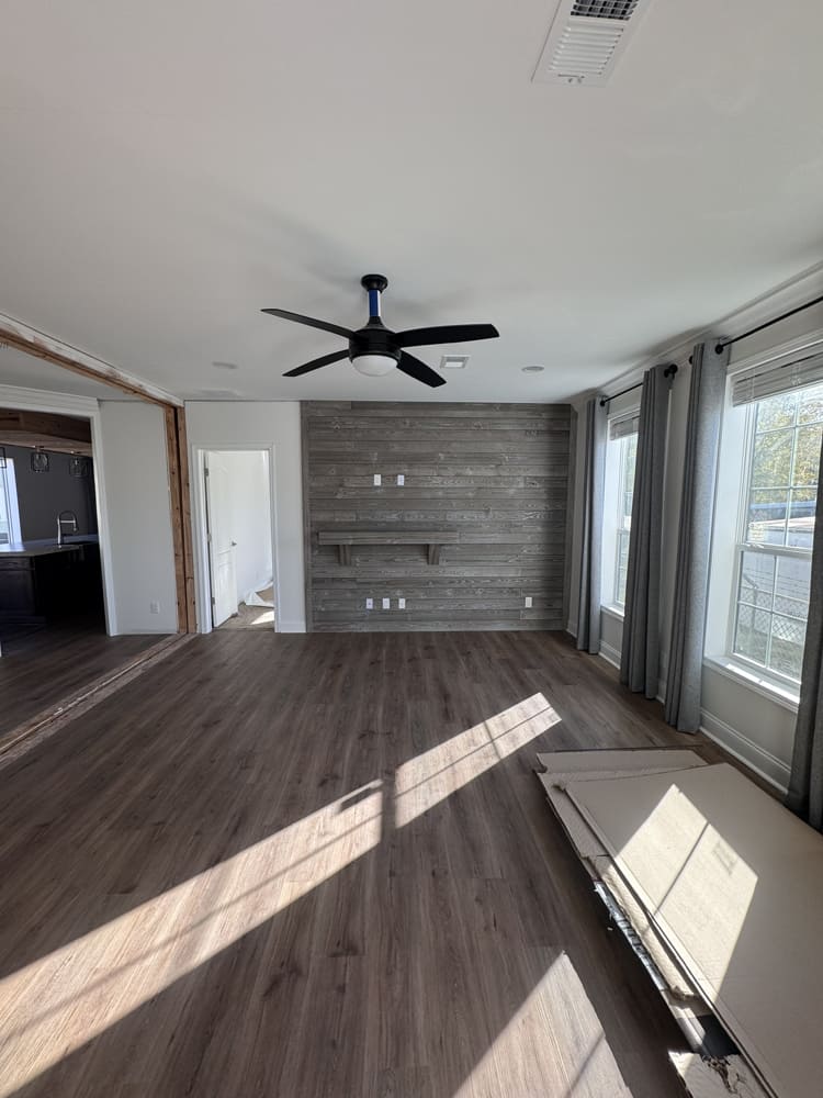 Open living area with wood-look flooring in The Shoreline double-wide home
