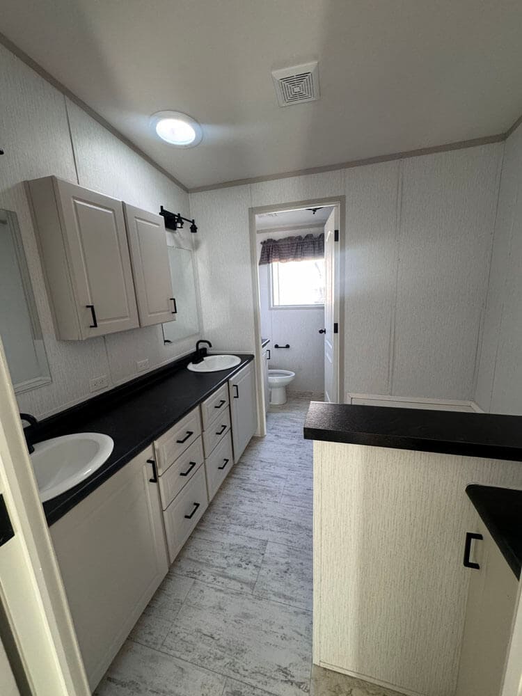 Primary bathroom with double vanity and private toilet room in The Lucia