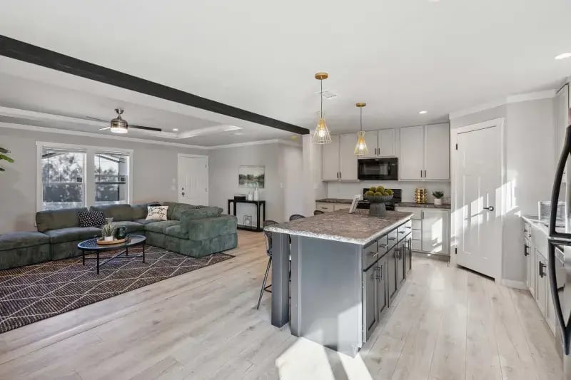 Spacious kitchen island and open living area in The Carol by Champion Homes
