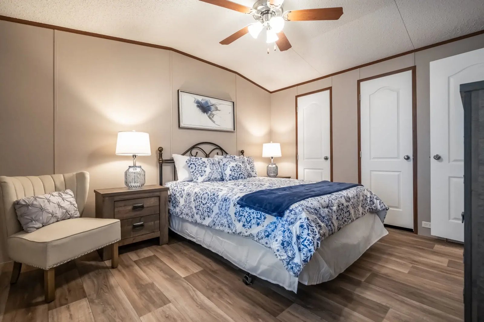 Alternate view of The Lisa primary bedroom with bedside tables, an accent chair, ceiling fan, and multiple interior doors