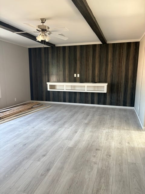 Primary bedroom with dark accent wall and ceiling fan in doublewide #180