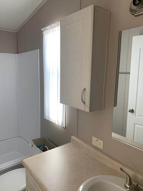 Tiny Hacienda bathroom with vanity, mirror, and tub