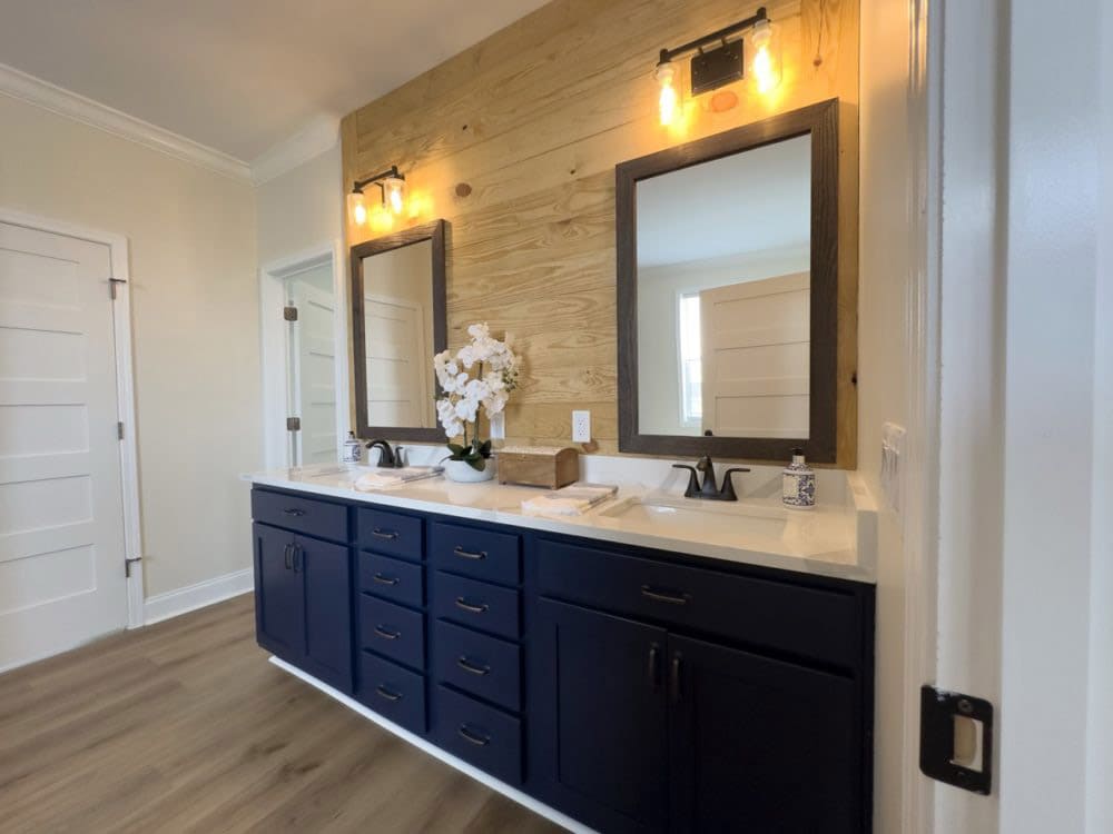 Double-sink vanity with wood accent wall in The Riverwalk primary bath