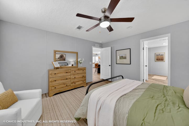 Primary bedroom with ceiling fan in The Vantage by Cavco