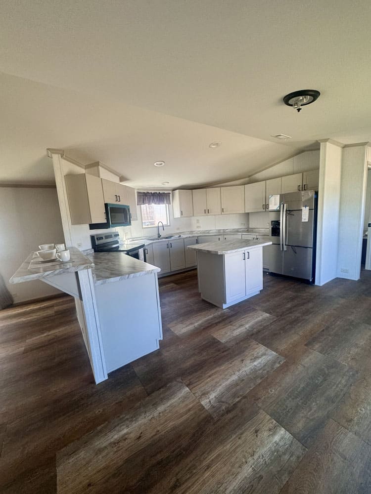Large kitchen with island and stainless appliances in the H-1880-32E