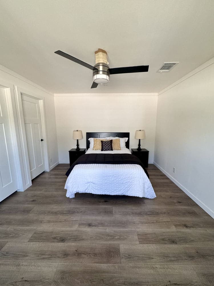 Primary bedroom with wood-look flooring in The Cami Ascend singlewide